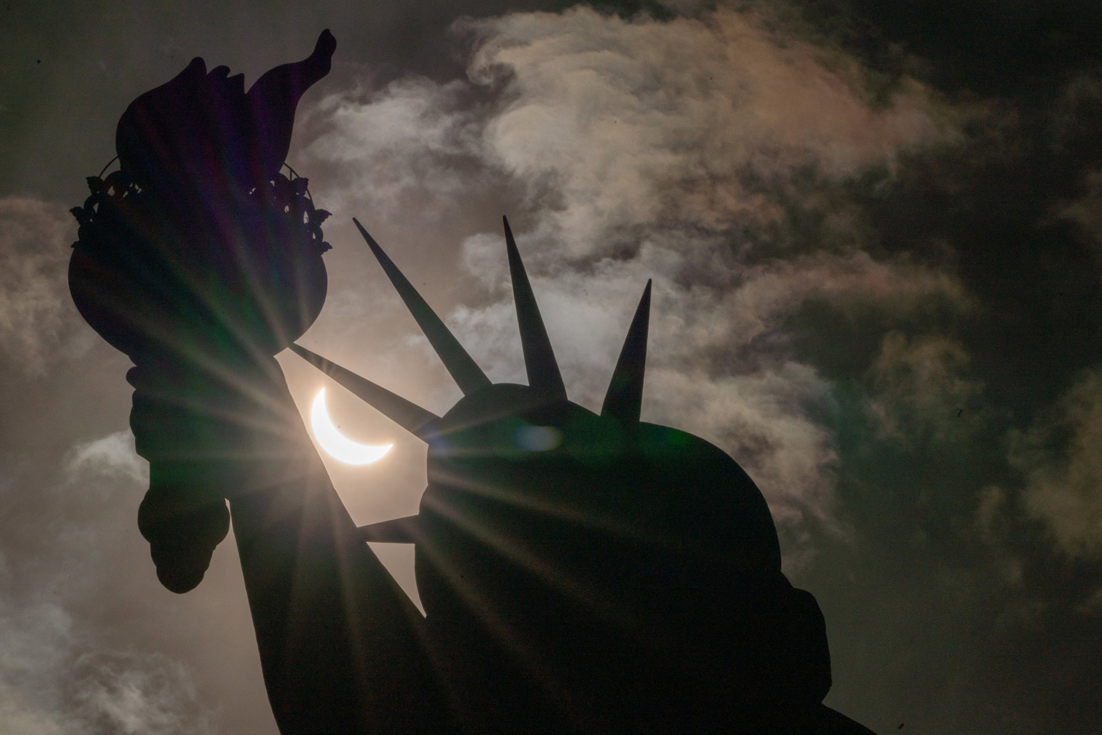 The Statue of Liberty is seen during a partial solar eclipse at Liberty Island in New York City - 8 April 2024 (David Dee Delgado/Reuters)