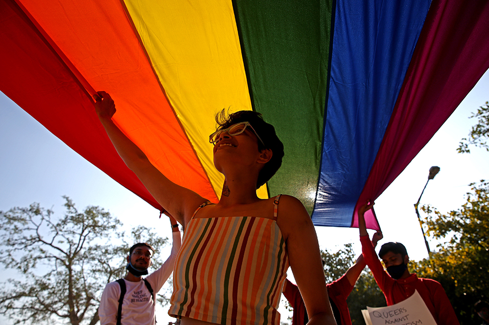Tres personas participan de una marcha del orgullo gay