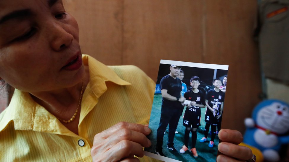 Abuela de Duangpetch Promthep, uno de los niños atrapados en Tailandia, muestra una foto del menor