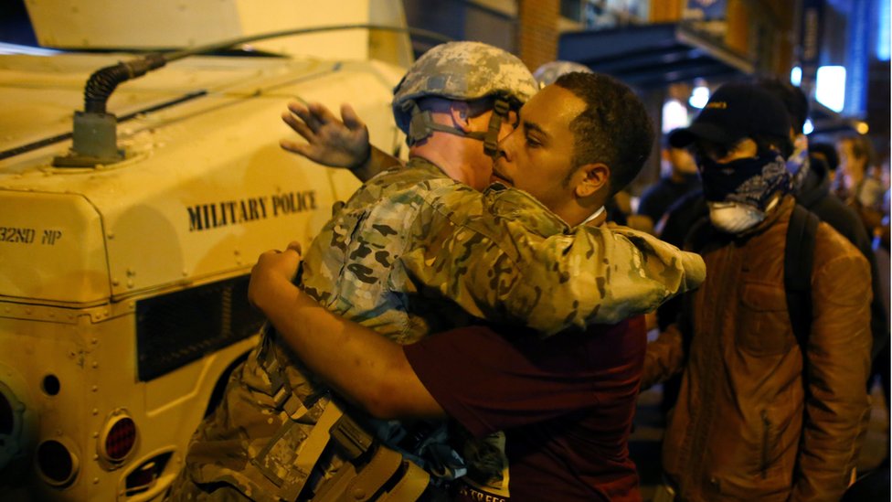 Солдат Национальной гвардии США обнимает протестующего в третью ночь протестов в Шарлотте, Северная Каролина