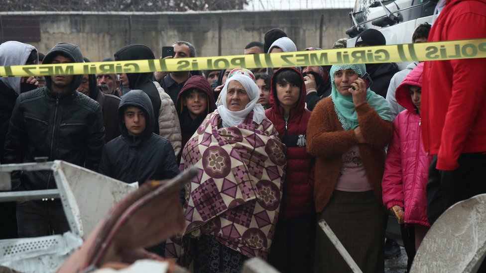 People watch as rescue operations take place on a site after an earthquake in Diyarbakir, Turkey on 6 February 6 2023