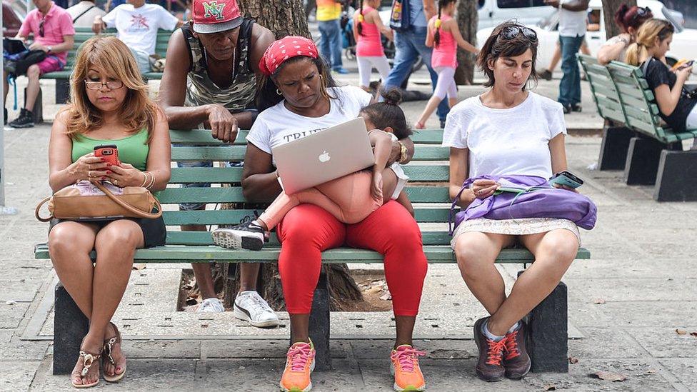 Cubanos utilizando aparatos conectados a internet.