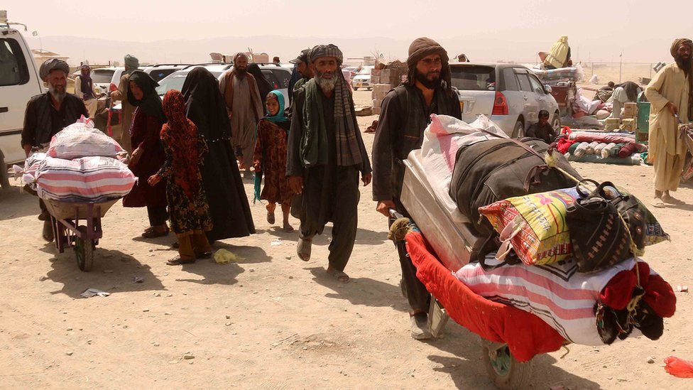 Afganos llevan sus posesiones en carretilla hasta la frontera