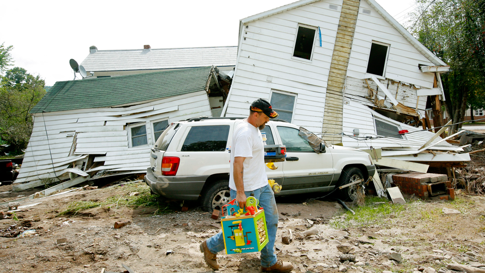 Un hombre pasa frente a una casa destruida por el Huracán Irene en Prattsville, Nueva York