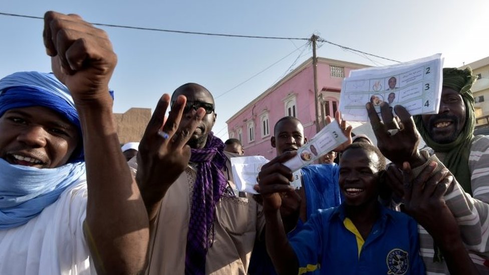 Избиратели жестикулируют и держат в руках бюллетени в Мавритании