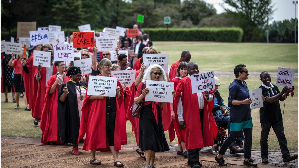 Преподаватели и сотрудники Университета Витватерсранда проводят демонстрацию в поддержку движения за бесплатное образование и против насилия на территории кампуса 30 сентября 2016 года в Йоханнесбурге.