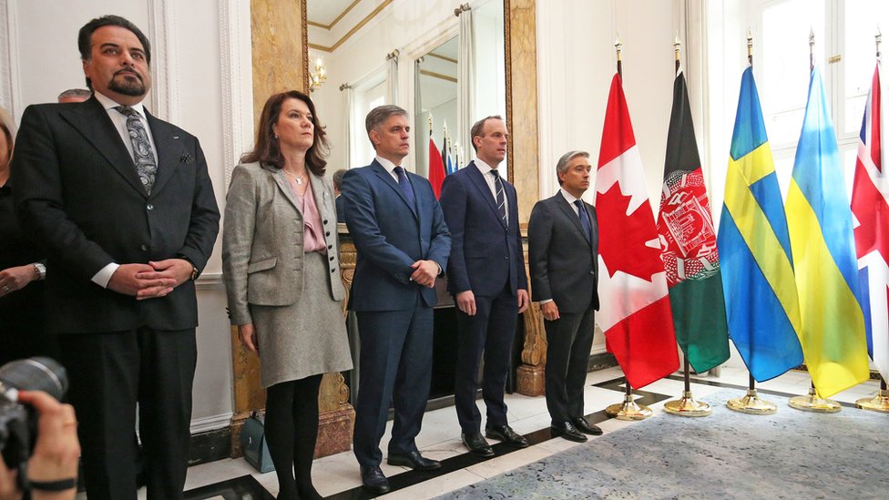 (Слева направо) Министры из Афганистана, Швеции, Украины, Великобритании и Канады стоят в ряд, размышляя о трагедии