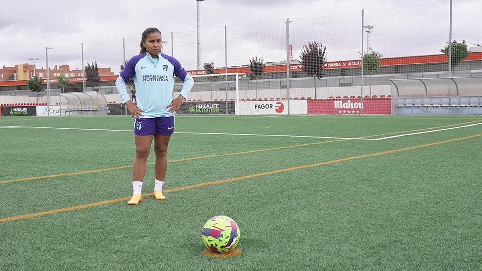 Leicy Santos on a football pitch behind a football