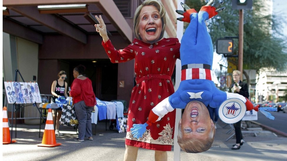 Человек в маске Хиллари Клинтон держит перевернутую марионетку Дональда Трампа, Феникс, Аризона, 20 октября 2016 г.