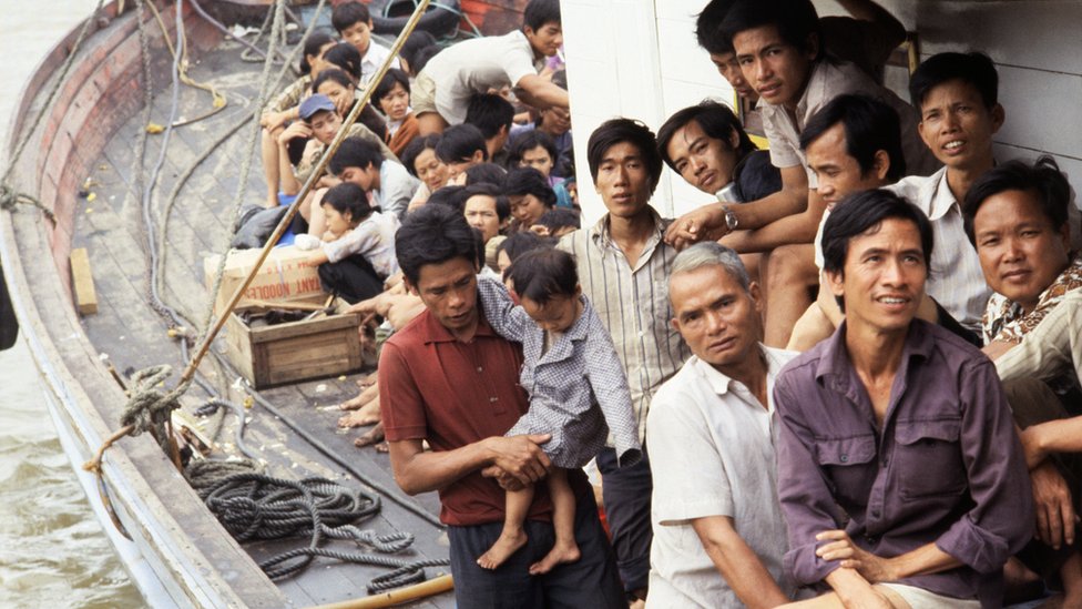 Фотография вьетнамских лодочников, втиснутых в деревянную лодку