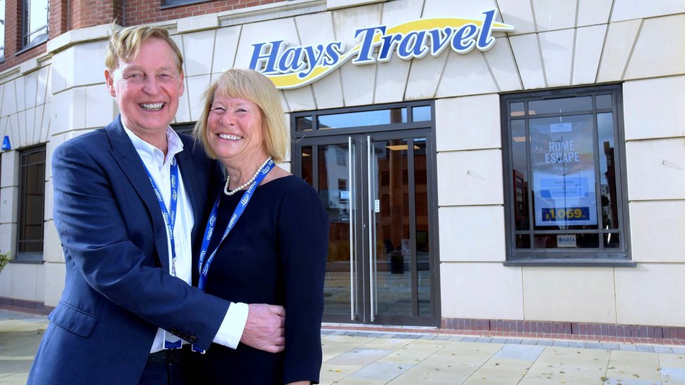 John Hays with wife Irene in front of a Hays Travel shop