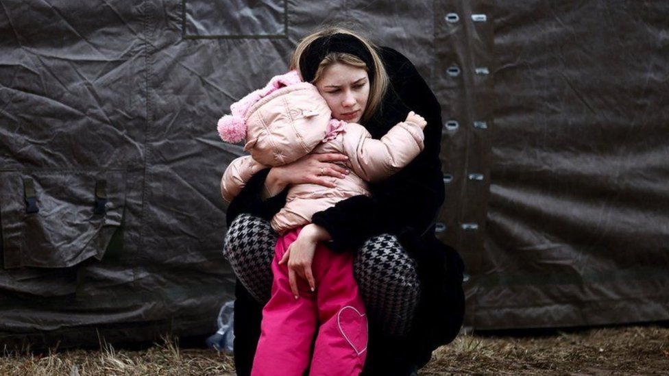 Una mujer ucraniana que huye de la invasión rusa abraza a un niño en un campamento temporal en Przemysl, Polonia.