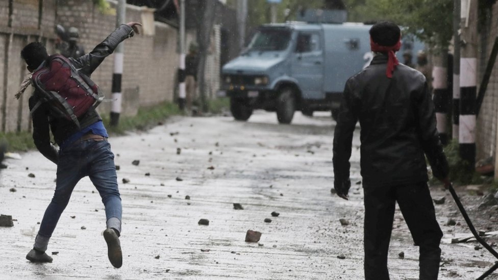 Кашмирский студент бросает камень в полицию во время столкновений у государственного Кашмирского политехнического колледжа в Сринагаре, 29 апреля 2017 г.