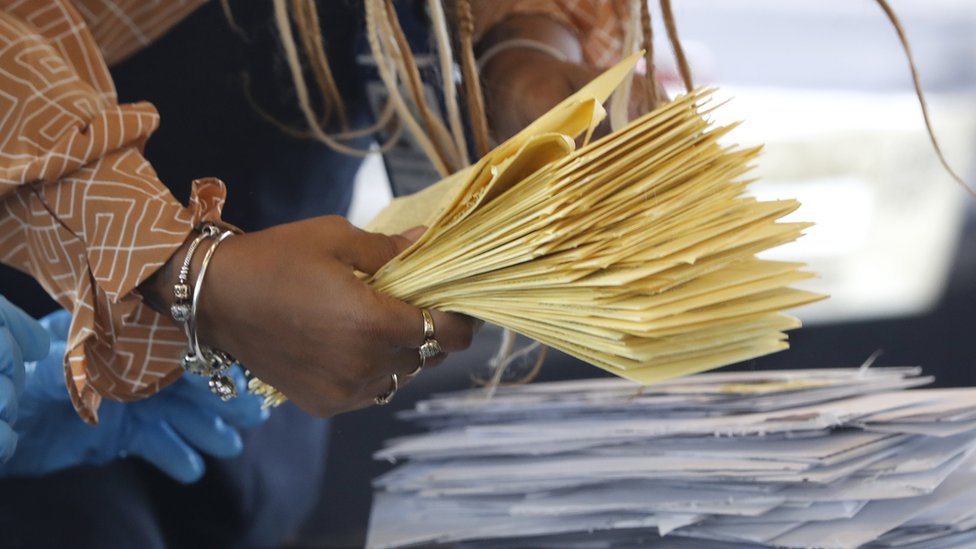 Person holding stack of ballots