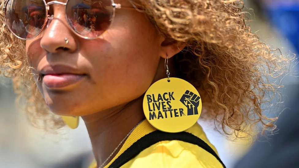 Žena sa minđušama na kojima je ispisan slogan pokreta za ljudska prava Afroamerikanac