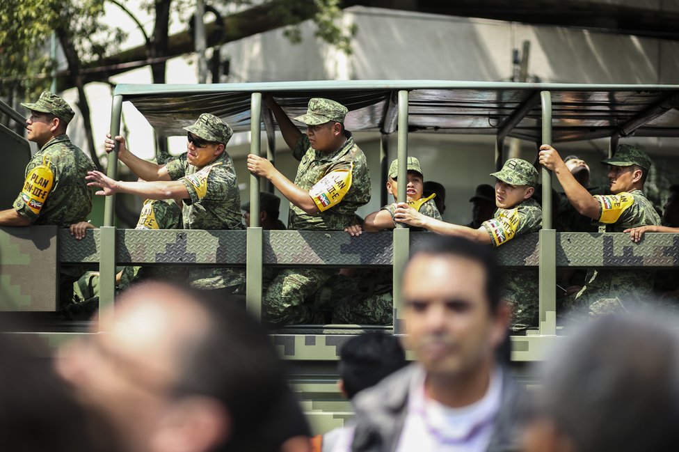 Мексиканские солдаты, изображенные в машине, носят характерную желтую повязку на руке, которая показывает, что они реагируют на катастрофу