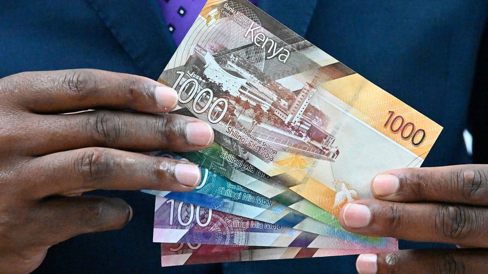 Патрик Ньороге показывает некоторые из новых дизайнов банкнот Кении