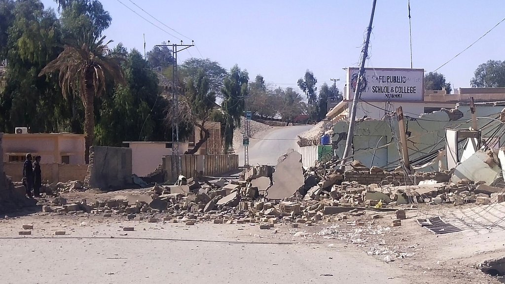 Security personnel (L) stand beside a destroyed security post following overnight attacks by militants on security camps in Naushki district of Balochistan province on February 3, 2022. (Photo by AFP) (Photo by -/AFP via Getty Images)