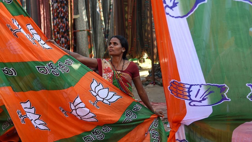 Индийский рабочий сушит красочные материалы, посвященные кампаниям партии Бхартия Джанта (BJP) и партии Конгресс в преддверии всеобщих выборов в Индии на окраине Ахмедабада 11 марта 2019 г.
