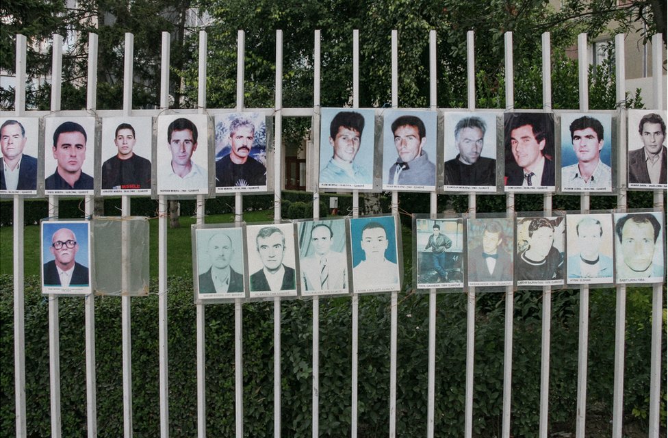 К перилам прикреплен забор с фотографиями пропавших без вести