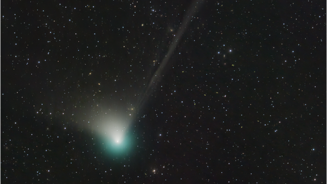 Un cometa verde deja su estela en un firmamento estrellado