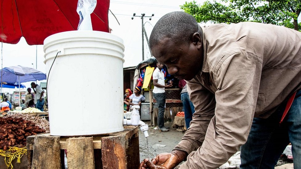 Мужчина моет руки хлорированной водой на рынке Мабибо в Дар-эс-Саламе, Танзания, 16 апреля 2020 г.