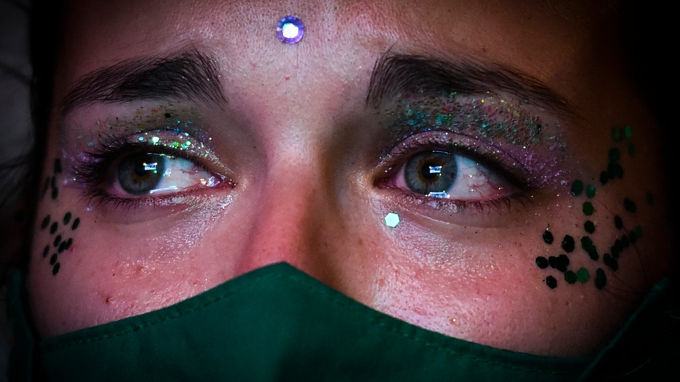 Joven con un pañuelo verde aguarda con lágrimas en los ojos afuera del Congreso argentino sobre el aborto
