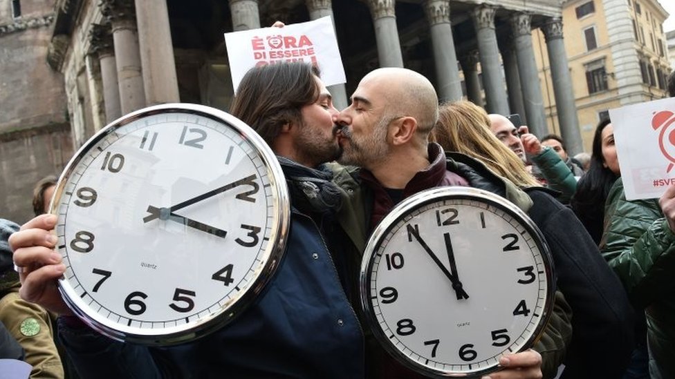 Пара, держащая будильники, целуется в Риме. Фото: 23 января 2016 г.