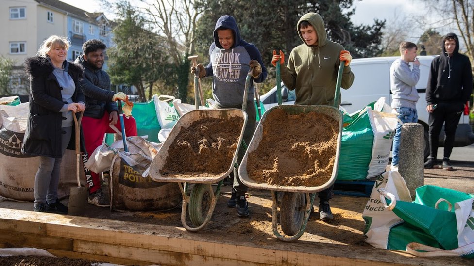 كيف تُحول بعض الشركات الوقت إلى عملة؟ 4 Two young men doing some voluntary work via Timebanking UK