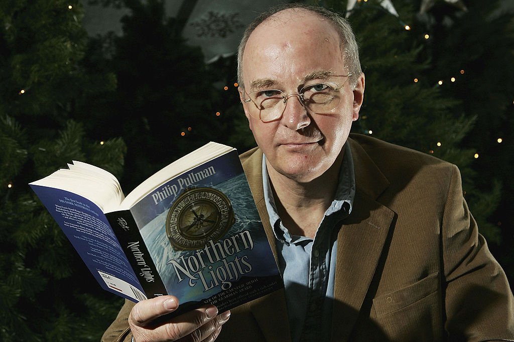 Philip Pullman sosteniendo su libro "Luces del norte"