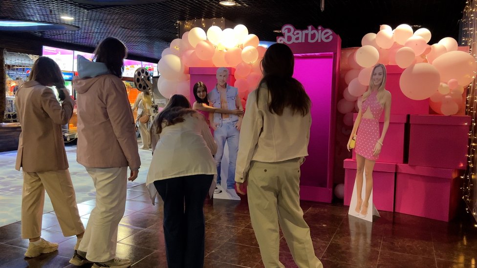 Russians queue up to have photos taken with cardboard cut outs from the Barbie film