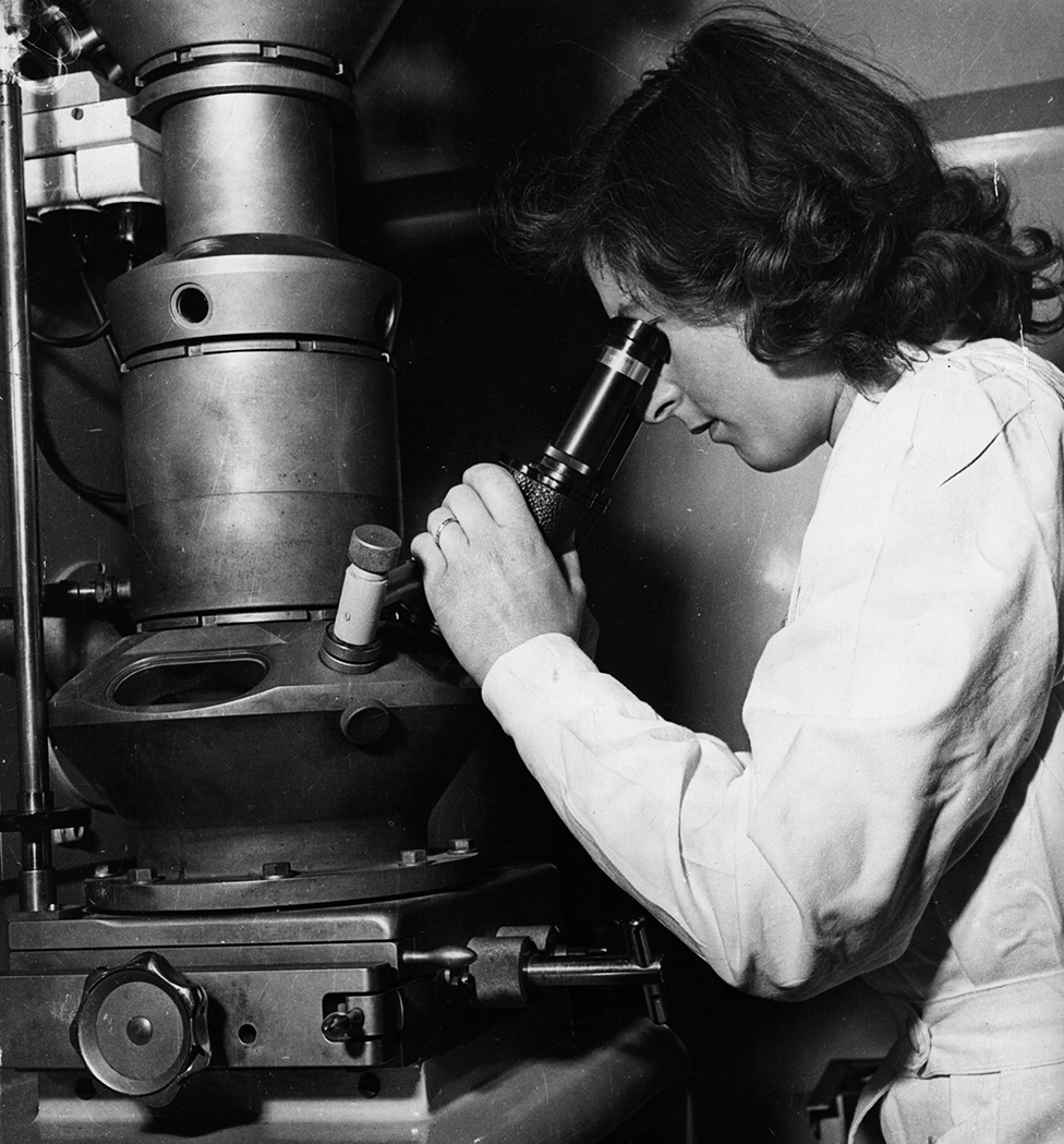 Una científica utiliza un microscopio electrónico en 1950 en Londres