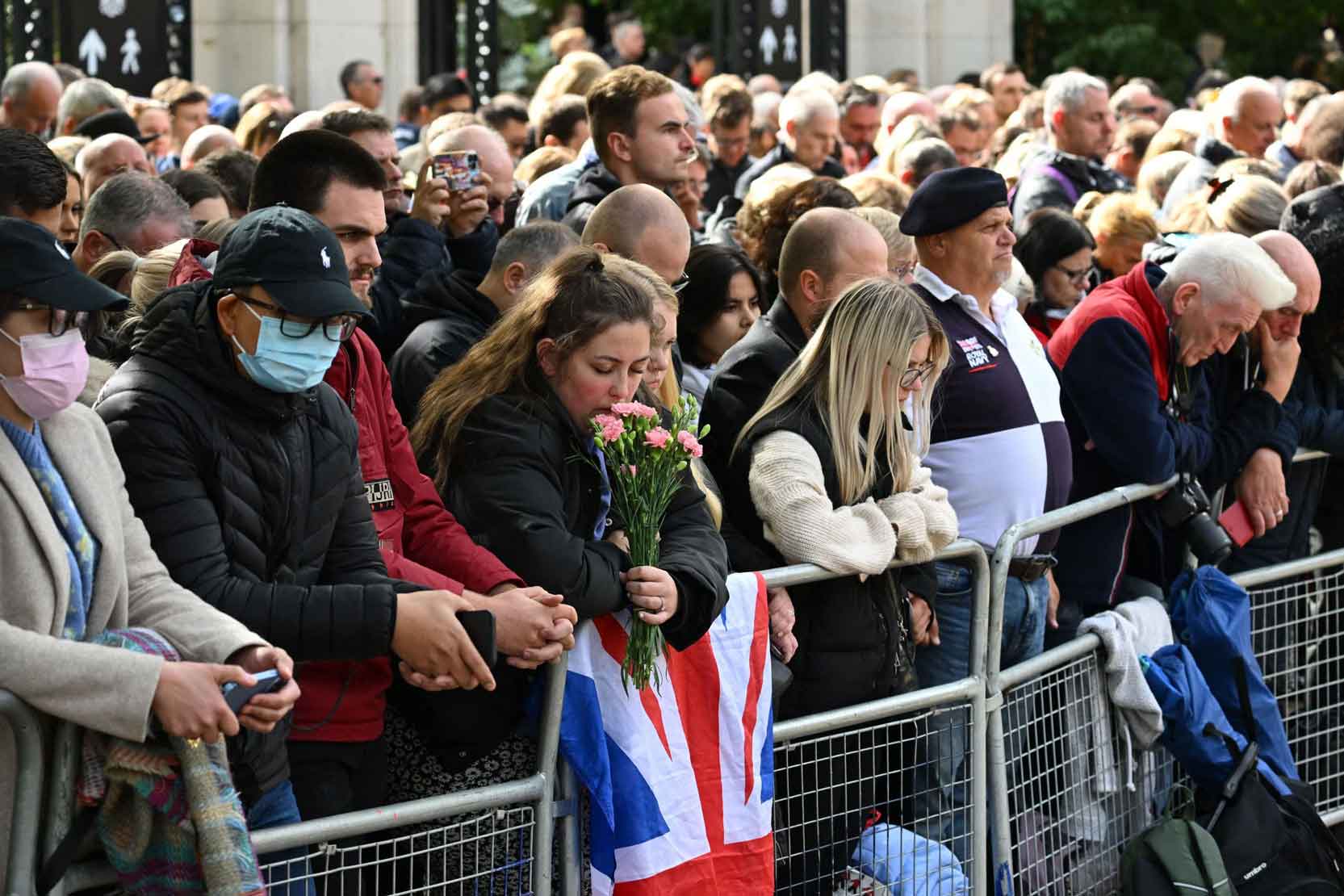 Crowds in London bow their heads.