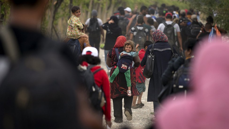 Мигранты идут по грунтовой дороге после пересечения македонско-греческой границы недалеко от Гевгелии, Македония (06 сентября 2015 г.)