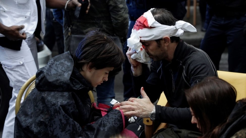 An injured man with a bloodied bandage round his head