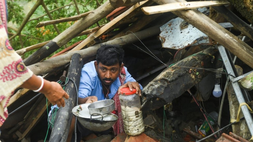 Una persona afectada por el ciclón intenta recuperar algunas pertenencias de su casa devastada en Bangladesh.
