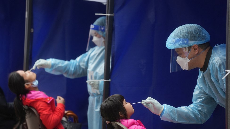 Medical workers take swab samples from residents at a community nucleic acid testing centre for the coronavirus disease (COVID-19) at Sha Tin district, in Hong Kong, China, February 7, 2022.
