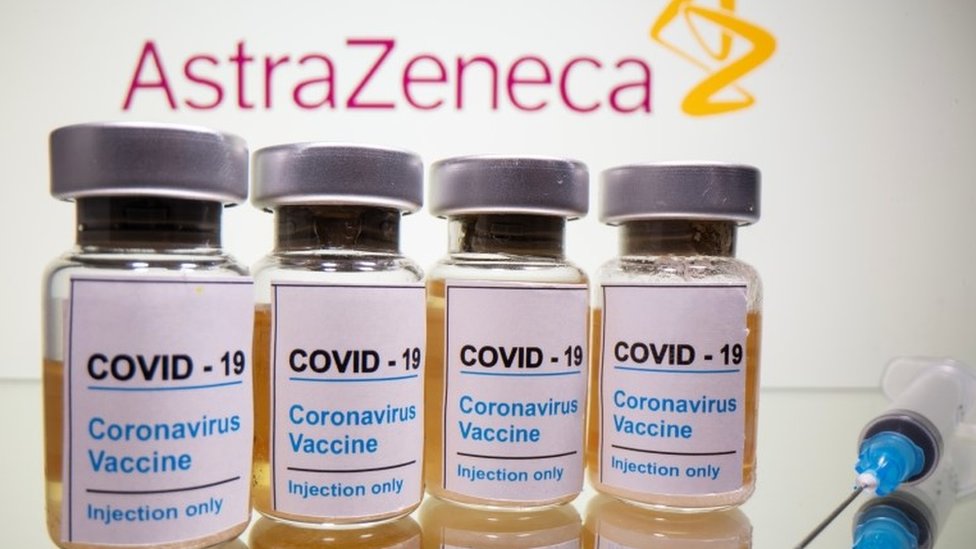 Vials with sticker reading, "COVID-19 / Coronavirus vaccine / Injection only" and a medical syringe are seen in front of an AstraZeneca logo displayed in this illustration taken on October 31, 2020.