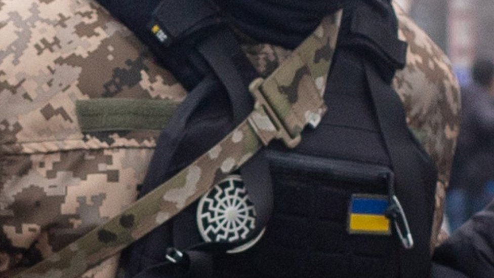 A detail of the black sun that appears on the uniform of a Ukrainian soldier