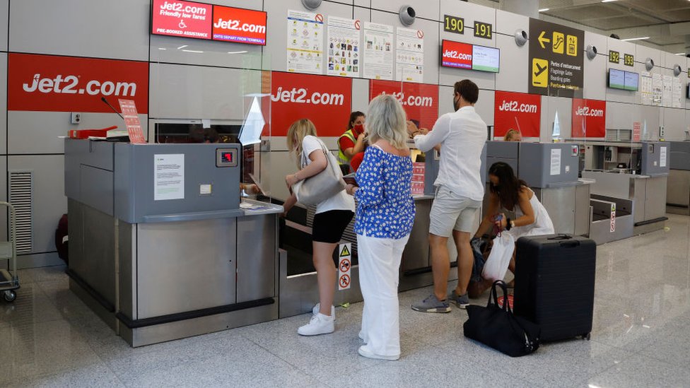 Пассажиры выстраиваются в очередь у стойки регистрации Jet2 в аэропорту Пальма-де-Майорка на Майорке