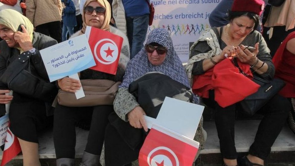 تونسيات يحملن لافتتات مطالبة بالمساواة