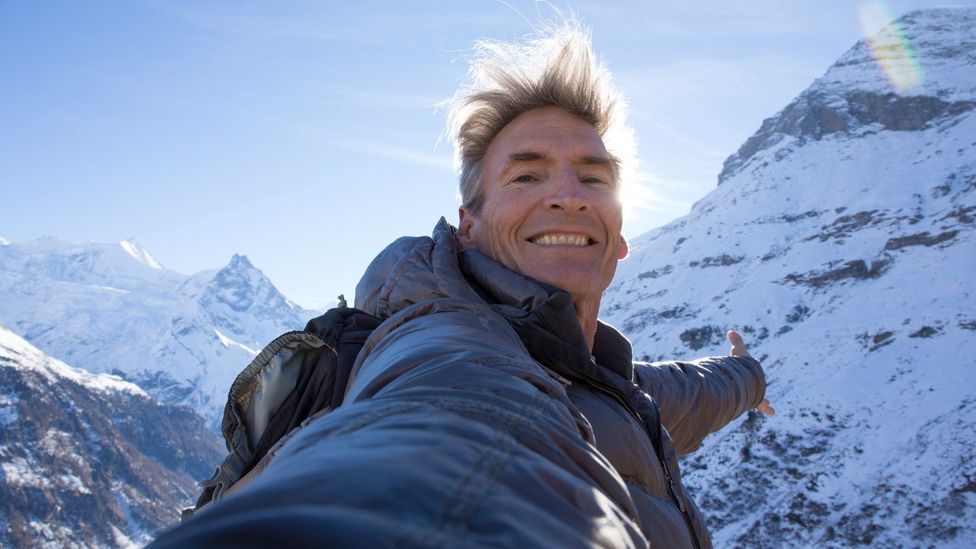 Homem fazendo selfie em montanha coberta de neve