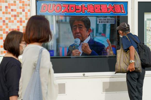 Japoneses viendo una pantalla donde se enteran de la noticia del asesinato de Shinzo Abe