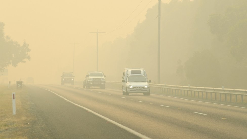 Машины эвакуируются через густой дым, вызванный пожарами в Виктории