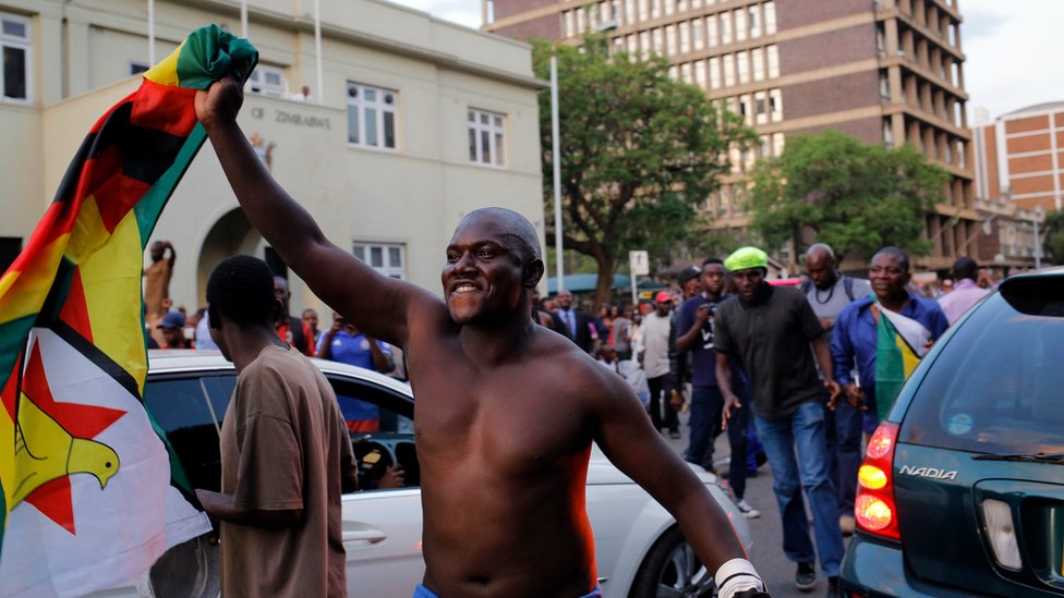 Las celebraciones en Harare comenzaron inmediatamente después que se supo de la renuncia del mandatario. Personas celebran en la capital de Zimbabue.