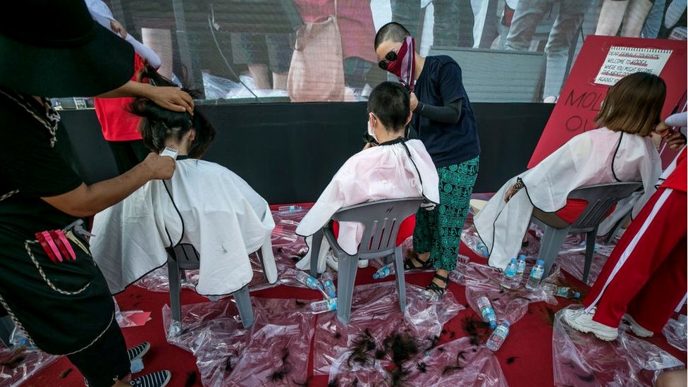 Женщины бреют головы на публичной акции протеста