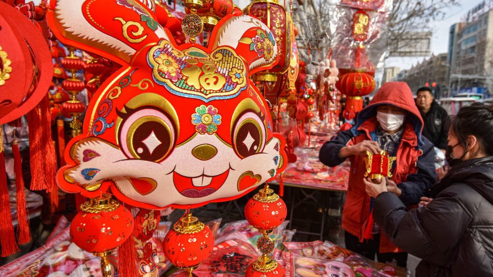 Clientes seleccionan las decoraciones del Festival de Primavera en un mercado de Año Nuevo en Renmin Road en la ciudad de Fuyang.