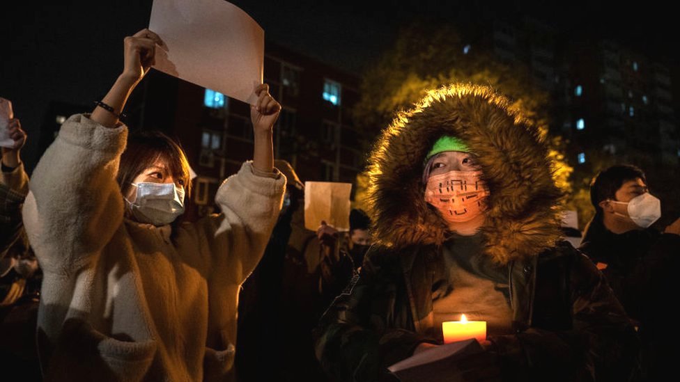 2022年11月27日，在北京的抗議者手持蠟燭作為抗議象徵的白紙。