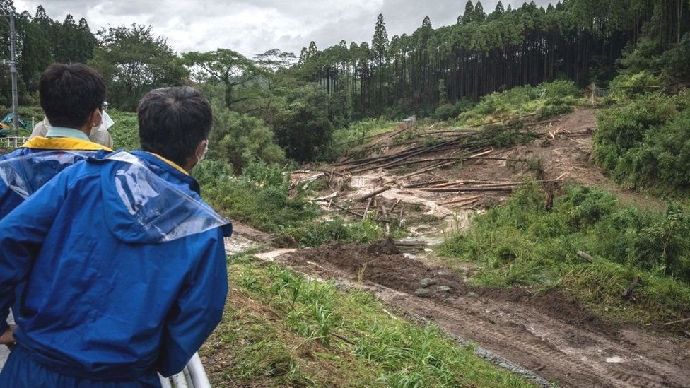 عمال يتفقدون موقع الانهيار الأرضي الذي تسبب فيه إعصار نانمادول في ميماتا بمدينة ميازاكي