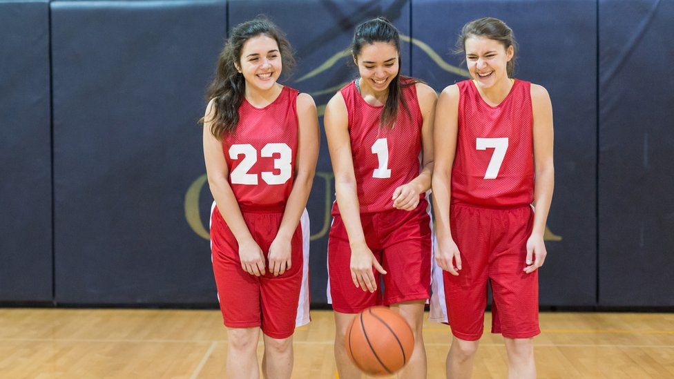 Tres adolescentes miembros del mismo equipo de baloncesto.